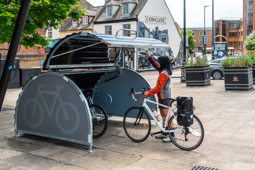 A woman parking a bike in a Bikehangar